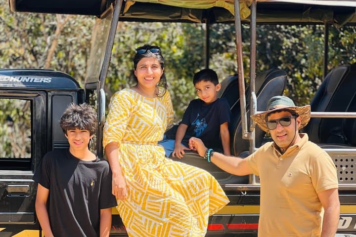A family posing together on their safari jeep